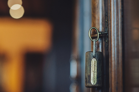 Silhouette of door keys hanging on the open doorの写真素材
