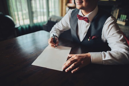 The handsome groom signing a documentの写真素材