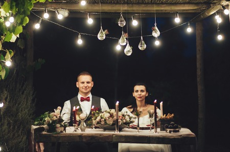 Bride and groom hugging Labrador dog at wedding celebrationの写真素材