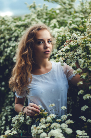 Woman in spring blossom. Young naturally beautiful woman near thの写真素材