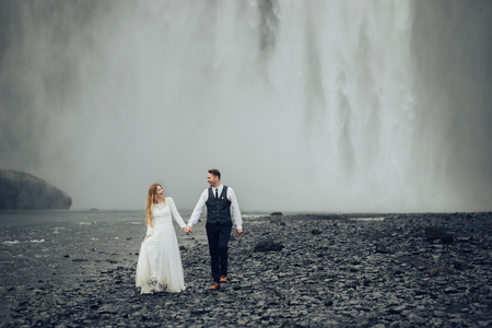Happy stylish smiling couple walking and kissing in Icelandの写真素材