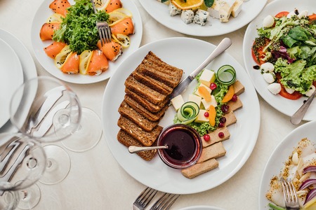 Served dishes to the table for holiday. Cutlery and food on whitの写真素材
