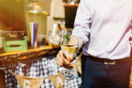 Man with a glass of white wine in handの写真素材