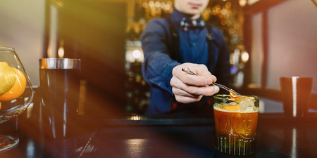 Expert Bartender is making cocktail at bar.の写真素材
