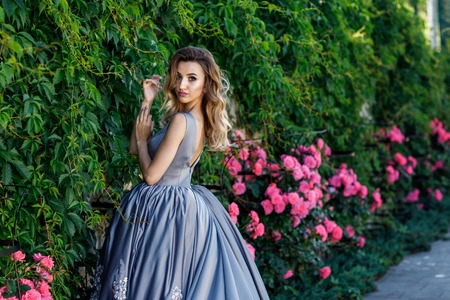 Beautiful girl with roses. Beauty model woman face. Perfect Skinの写真素材