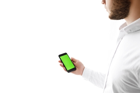 Man using mobile phone while standing near window.の写真素材
