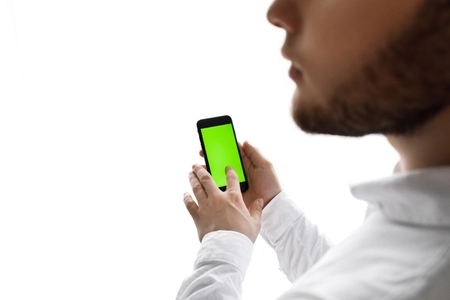 Close-up of male hands using smartphone near the window. Close upの写真素材