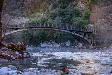 Fall scenery in voidomatis river with the famous clear waters and a  bridge as background  in epirus Greece.の写真素材