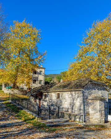 Traditional stone building with mountain as background    during  fall season in the picturesque village of Aristi in Zagori Greece.の写真素材
