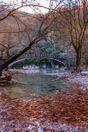 Fall scenery in voidomatis river with the famous clear waters and a  bridge as background  in epirus Greece.の写真素材