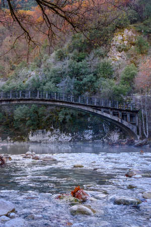 Fall scenery in voidomatis river with the famous clear waters and a  bridge as background  in epirus Greece.の写真素材