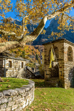Taxiarchon stone bell tower   church  during  fall season in the picturesque village of Mikro ...