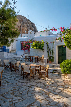 Traditional cycladitic   alley with an exterior of a traditional cafe, a whitewashed  church and  blooming flowers in Chora Amorgos  Greeceの写真素材