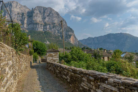 Traditional architecture with  narrow  stone street  and  astraka mountain as background during  fall season in the village Papigo in zagori Greeceの写真素材