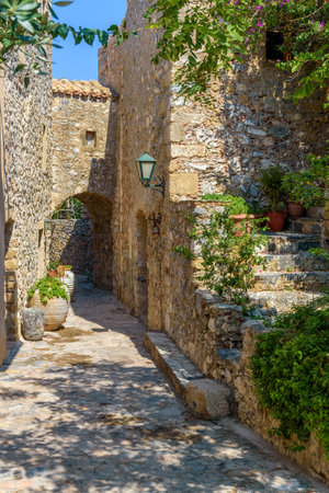 Traditional architecture with  a narrow  stone street and a colorfull bougainvillea in  the medieval  castle of Monemvasia, Lakonia, Peloponnese, Greece.の写真素材