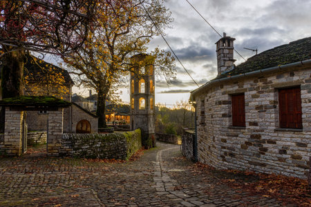 Î¤raditional architecture  with a narrow street and  stone buildings during  fall season in the picturesque village of papigo , zagori Greeceの写真素材