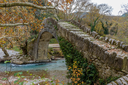 Old stone bridge in Klidonia  during fall season.  This arch bridge was built in 1853 and it is situated on the river of Voidomatis in  Zagori, Epirus Greece.の写真素材