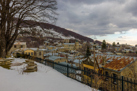 Î¤raditional architecture  with  stone buildings and the famous nikios school writen in greek language  during  winter season in the picturesque village of Nymfaio  Florinas Greeceの写真素材