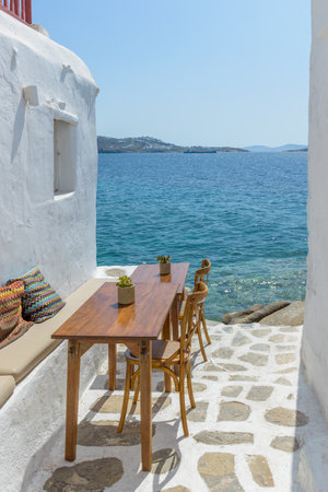 Traditional Cycladitic alley with a narrow street and an  exterior   of a tavern in Mykonos island, cyclades, Greeceの写真素材