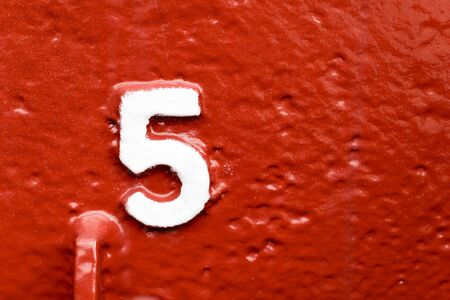 Numbers five on red wallの写真素材