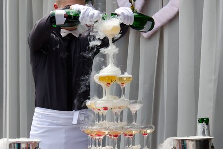 Catering service. Wedding slide champagne for bride and groom outdoors. Catering bar for celebrationの写真素材