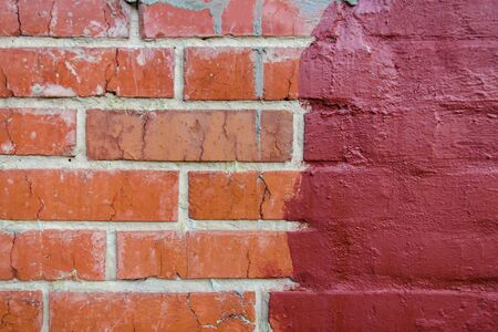 red brickwork half painted in dark paintの写真素材