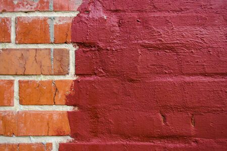 red brickwork half painted in dark red paintの写真素材