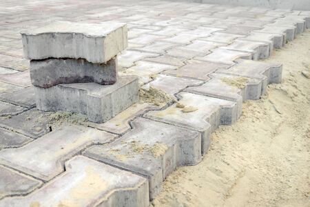 road work to replace paving slabs. repair of the sidewalk, paving slabs. laying new road tiles in the sandの写真素材