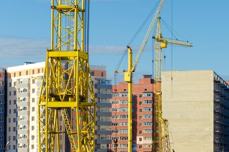 construction cranes are in the new quarter; a new housing estate is under construction. The concept of the construction of apartment buildingsの写真素材