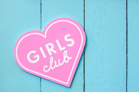 pink heart-shaped girl club sign on a blue fence background. concept of fashion promotionの写真素材