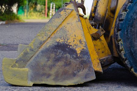 bulldozer scoop, closeup side view. scratched yellow bulldozer bucket. heavy construction equipment in construction and repair workの写真素材