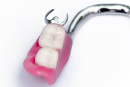half of the removable denture on the lower jaw. false teeth. implants. clasp prosthesis on the lower jaw. background. orthopedic dentistry. backgroundの写真素材