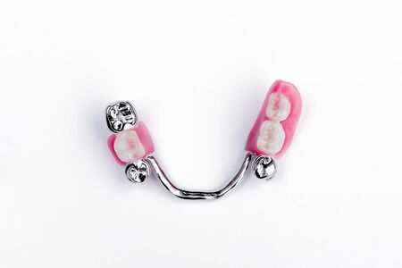 dental prosthetics concept. dentistry. dental prostheses. lower removable denture. lower clasp prosthesis with supporting crowns. White background. false lower teeth. ceramic teethの写真素材
