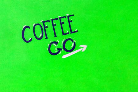 drawn inscription coffee to go with an arrow on a green wooden background. copy spaceの写真素材