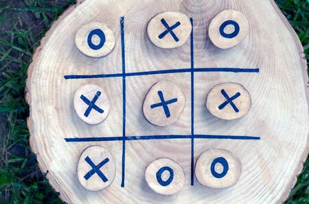 tic tac toe game on a wooden board with wooden tac toe and crosses. winner strategy, winning skill, vision of an idea, ability to lead, success strategy. Leadership conceptの写真素材