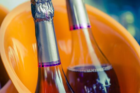 corked wine bottles are cooled in an ice bucket. holiday atmosphere. drinking alcohol outdoors. wedding celebration.の写真素材