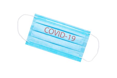 blue medical face mask with the inscription COVID-19 isolated on a white background. coronavirus pandemic conceptの写真素材
