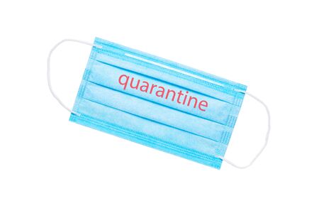 blue medical face mask with the inscription quarantine isolated on a white background. global quarantine concept. flat layの写真素材
