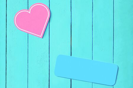 pink heart on a blue wooden background and a blue plate. copy space. Background for weddings, valentines day. romantic backgroundの写真素材