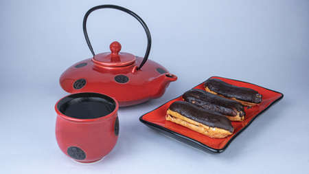 Teapot, cup and cakes on a plate.