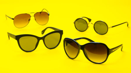 Several different style sunglasses on a yellow backgroundの写真素材