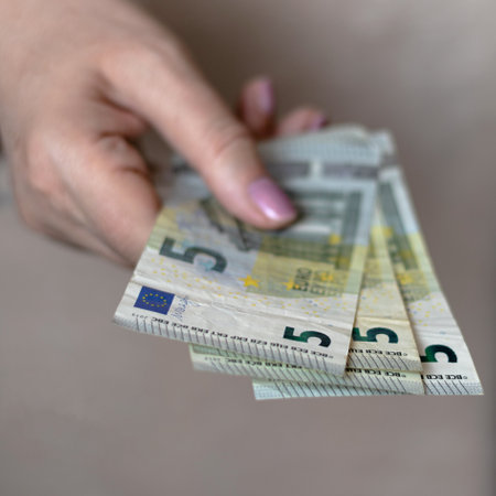 Four five euro bills in a woman's handの写真素材