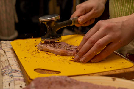 pork chop is beaten with a hammer of spices flying through the airの写真素材