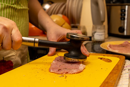 pork chop is beaten with a hammer of spices flying through the airの写真素材