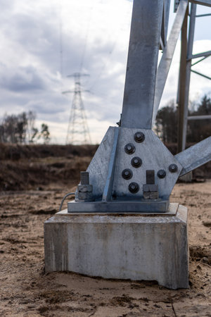 In the sandy soil, new concrete foundations and a metal leg were built. In the background visible metal construction for power transmission lines.の写真素材