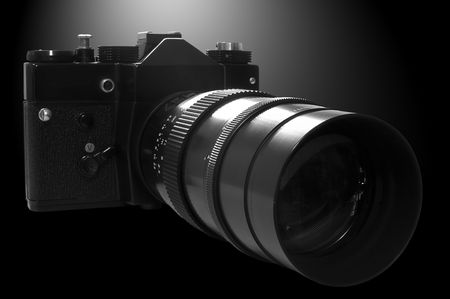 Retro SLR Camera in b&w on black background with lights coming from behind.の写真素材