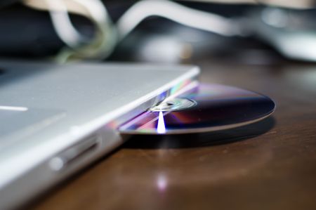 Latop with CD stuck in it.の写真素材