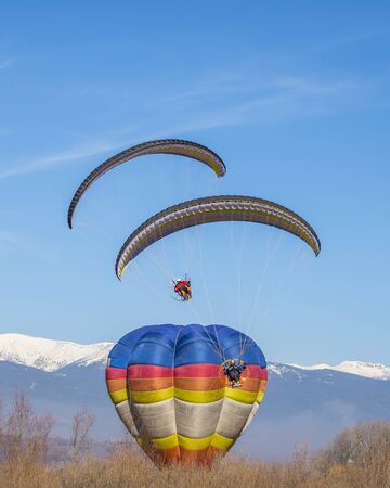Baloon with 2 moto gliders in the beatiful moountain in the winter colorの写真素材