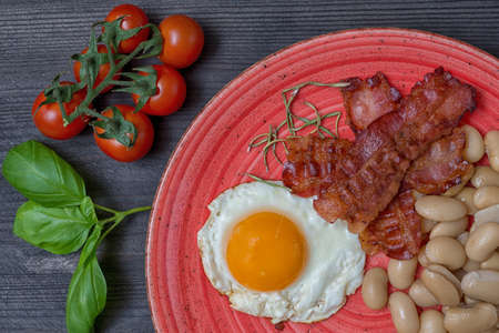 Farmer meals bean eggs bacon tomatto red plateの写真素材