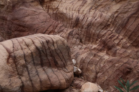 Colorful stone in front of a colorful wall in the Wadi Ghuweir canyon, Dana, Jordan 2021の写真素材